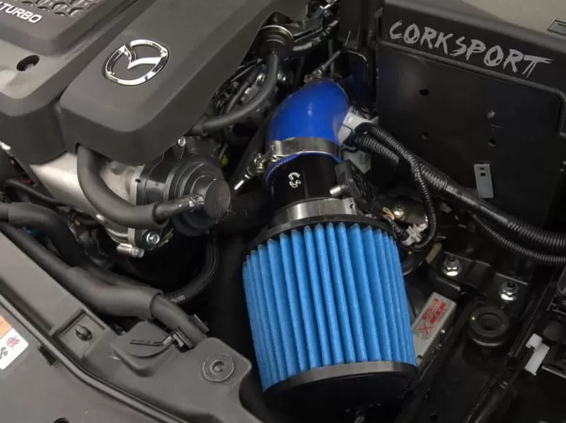 Blue silicone and filter shown with the black powder coated turbo inlet pipe and polished clamps installed on a Mazdaspeed6