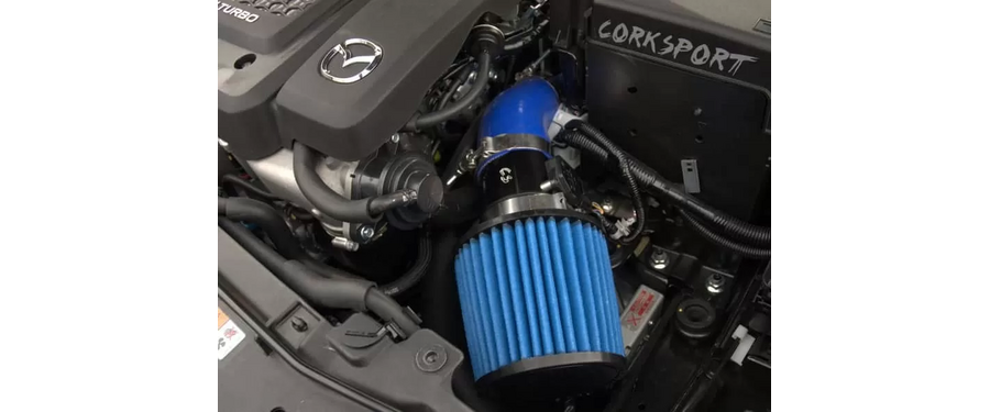 Blue silicone and filter shown with the black powder coated turbo inlet pipe and polished clamps installed on a Mazdaspeed6