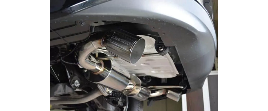 An angled view of the 2014+ Mazda 3 Sedan exhaust tip installed.